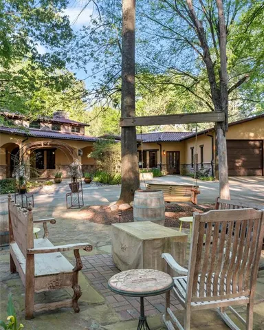 a view of house with backyard seating and tree
