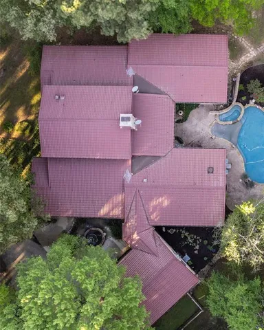 an aerial view of a house with a yard and lake