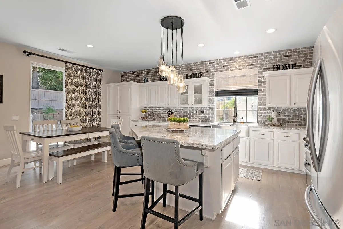 717 Via Cafetal San Marcos, CA 92069 - Photo 16 of 41 a kitchen with kitchen island granite countertop a sink cabinets and stainless steel appliances