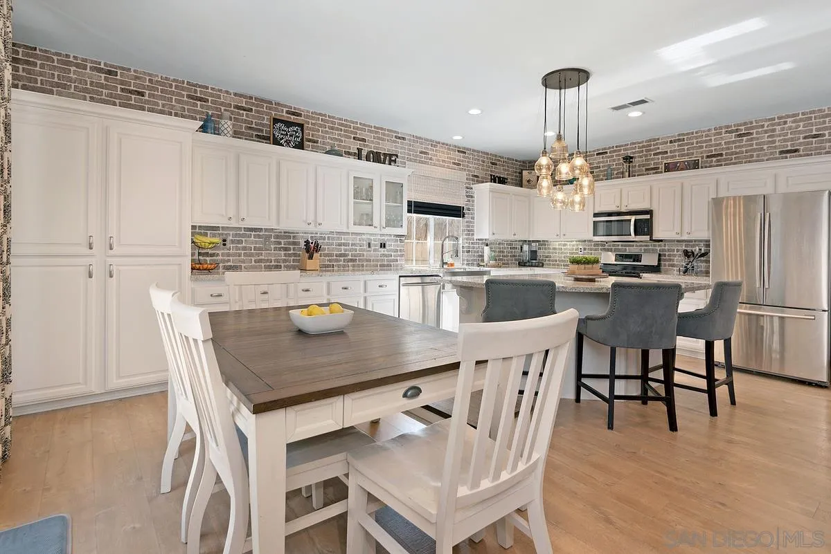 717 Via Cafetal San Marcos, CA 92069 - Photo 20 of 41 a kitchen with kitchen island a dining table chairs and white cabinets