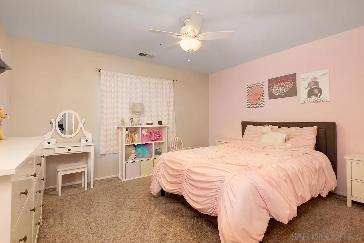 717 Via Cafetal San Marcos, CA 92069 - Photo 39 of 41 a bedroom with a bed and a chandelier