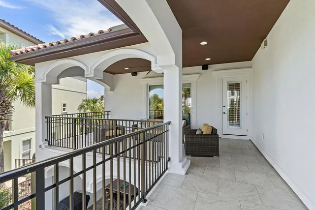a view of a brick house with large windows and a flower plants in front of it