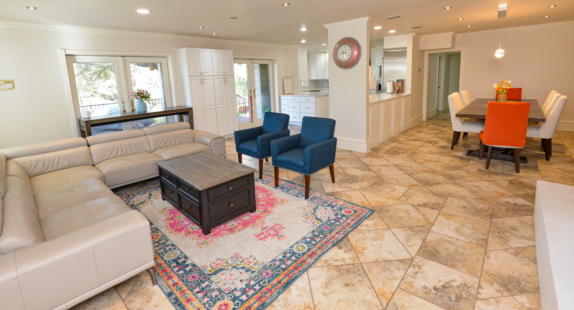 10710 D-K Ranch Road Austin, TX 78759 - Photo 6 of 34 An inviting open-concept living space features an elegant dining area, kitchen with island, and sun-filled living room, all with tiled floors.