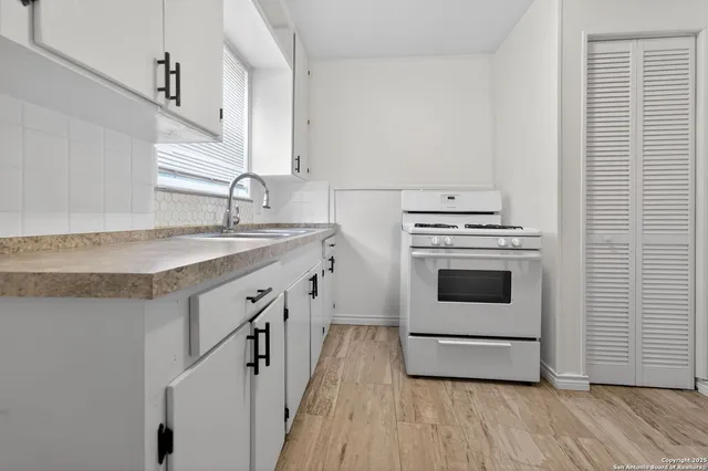 a kitchen with a stove cabinets and wooden floor