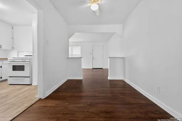 a view of a kitchen with wooden floor and a ceiling fan