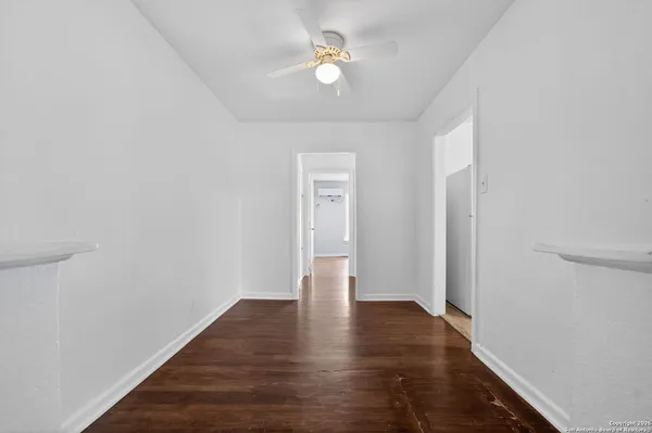 a view of an empty room with window and wooden floor