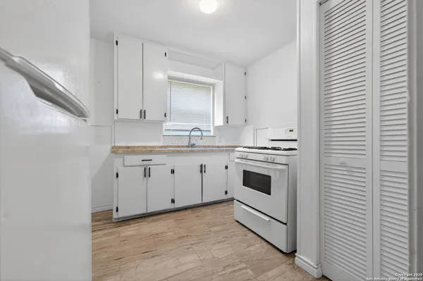 a kitchen with white cabinets stainless steel appliances and sink