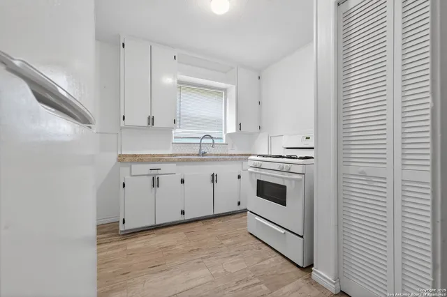 a kitchen with white cabinets stainless steel appliances and sink
