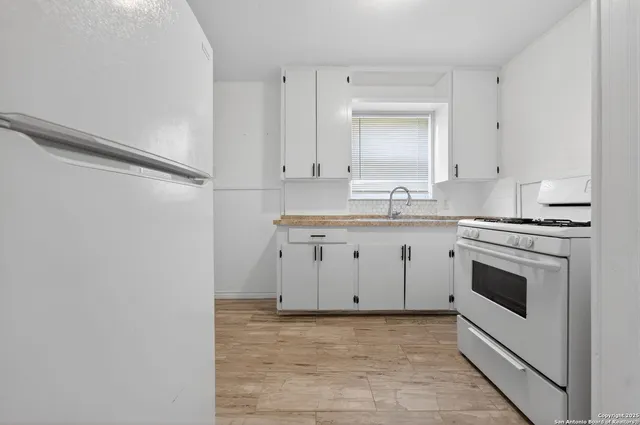 a kitchen with a sink stove and cabinets