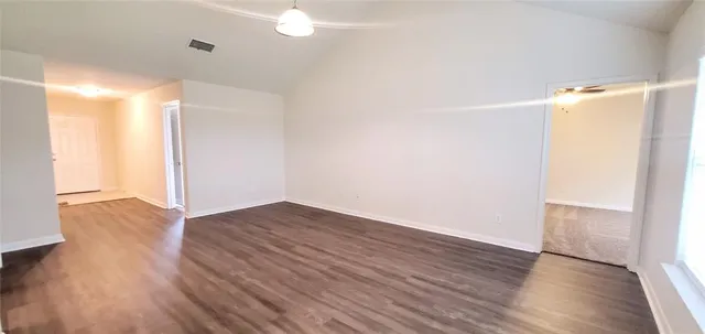 a view of an empty room with wooden floor