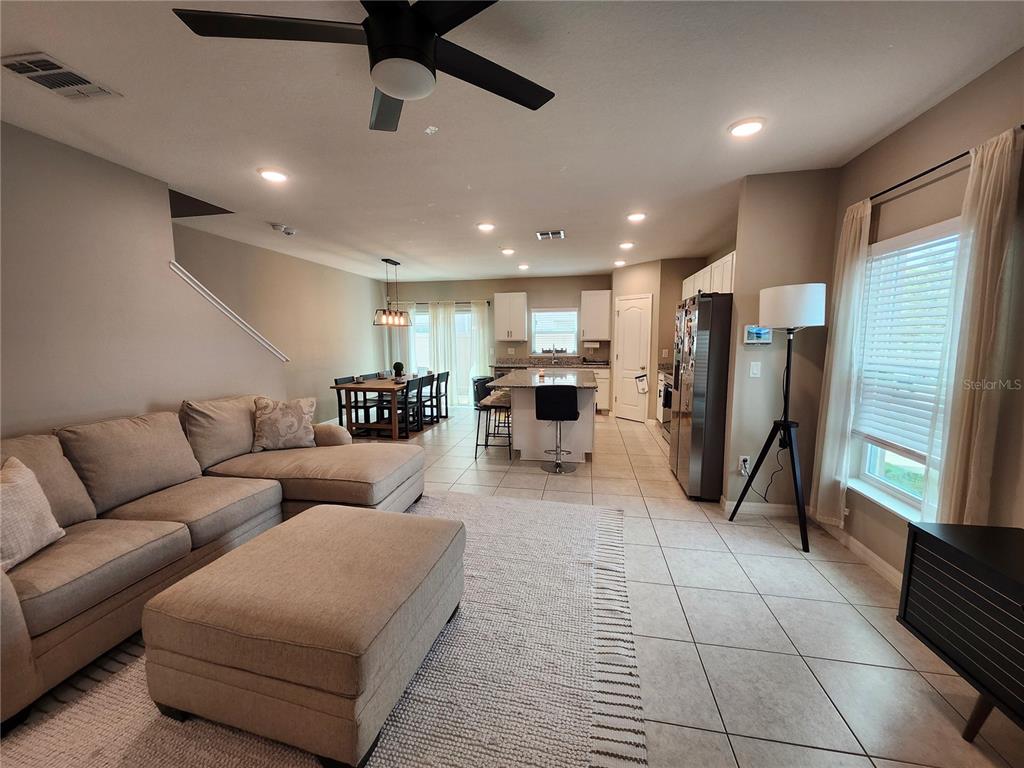 4718 Legendary Oak Street Tampa, FL 33610 - Photo 2 of 21 a living room with furniture a refrigerator and kitchen view
