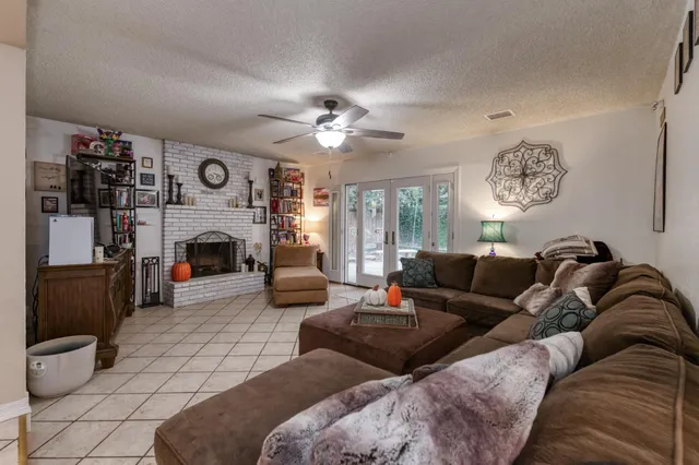 a living room with furniture a fireplace and a large mirror