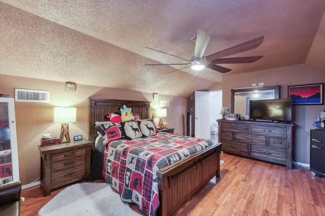 a bedroom with a large bed and a chandelier