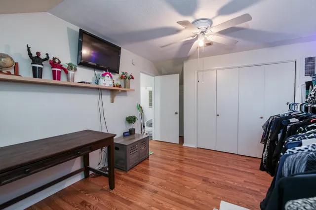 a room with chandelier fan and wooden floor