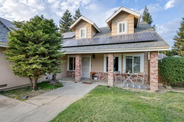a front view of house with a garden and patio