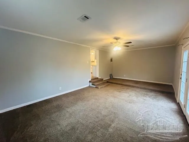 an empty room with a ceiling fan and window