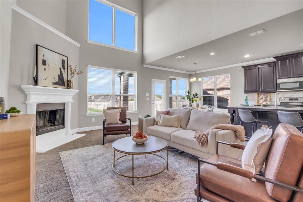 a living room with furniture fireplace and kitchen view