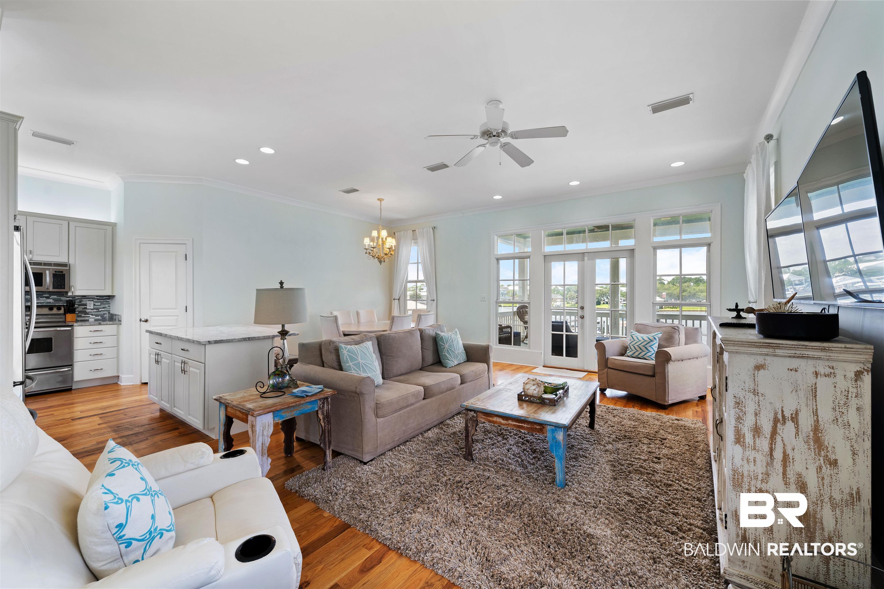 3434 Mariner Circle Orange Beach, AL 36561 - Photo 15 of 38 Living room featuring crown molding, french doors, ceiling fan with notable chandelier, and light hardwood / wood-style floors