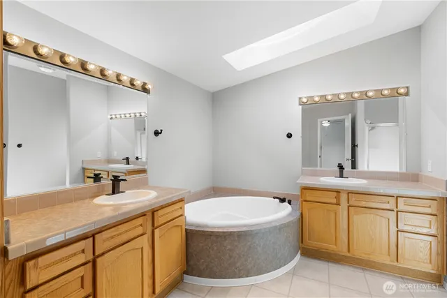 a bathroom with a granite countertop sink mirror and bathtub