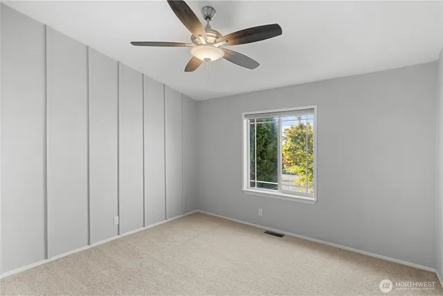 an empty room with fan and windows