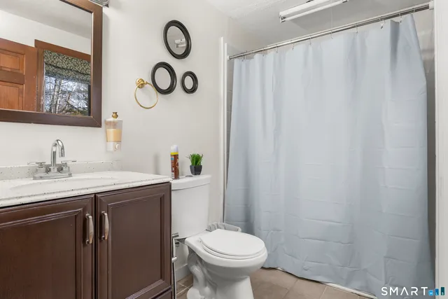 a bathroom with a sink vanity mirror and toilet
