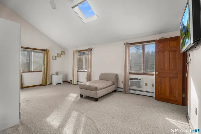 a view of an empty room with a window and a kitchen