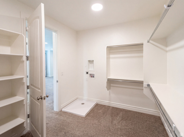 1251 North 2525 West Clinton, UT 84015 - Photo 26 of 30 Walk-in closet featuring extensive built-in shelving, multiple hanging rods, and a laundry hookup area with a washer pan