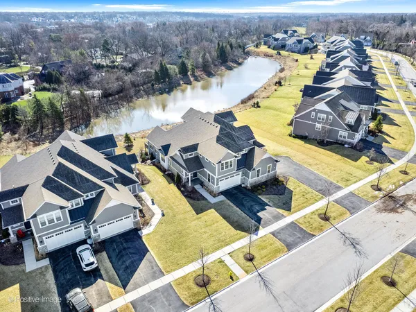 an aerial view of a swimming pool with outdoor seating and yard