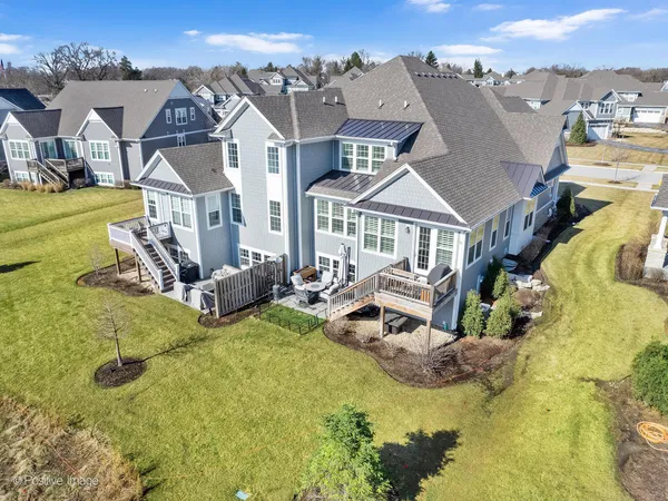 an aerial view of a house with swimming pool and a yard