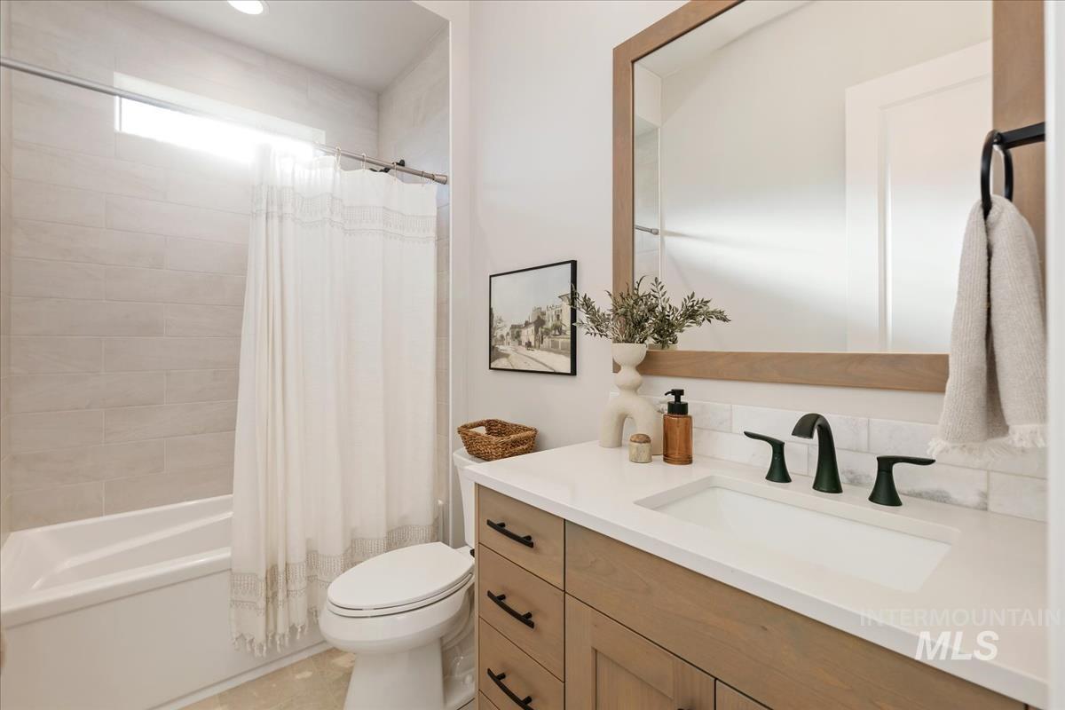 7355 Powell Place Eagle, ID 83714 - Photo 26 of 37 Bathroom featuring a single vanity with wood-finish cabinetry, a white countertop, and matte black fixtures