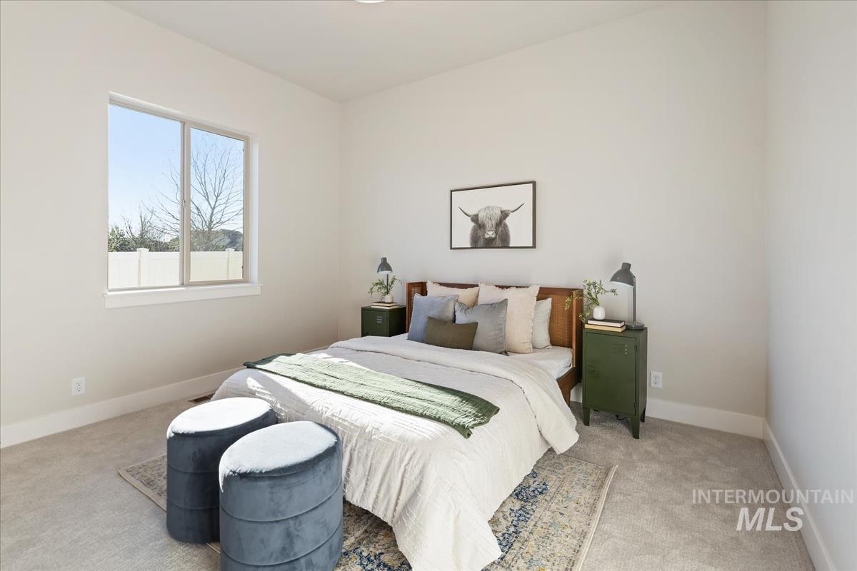 7355 Powell Place Eagle, ID 83714 - Photo 27 of 37 Spacious bedroom featuring light-toned walls, a large window with white trim, and soft carpeting