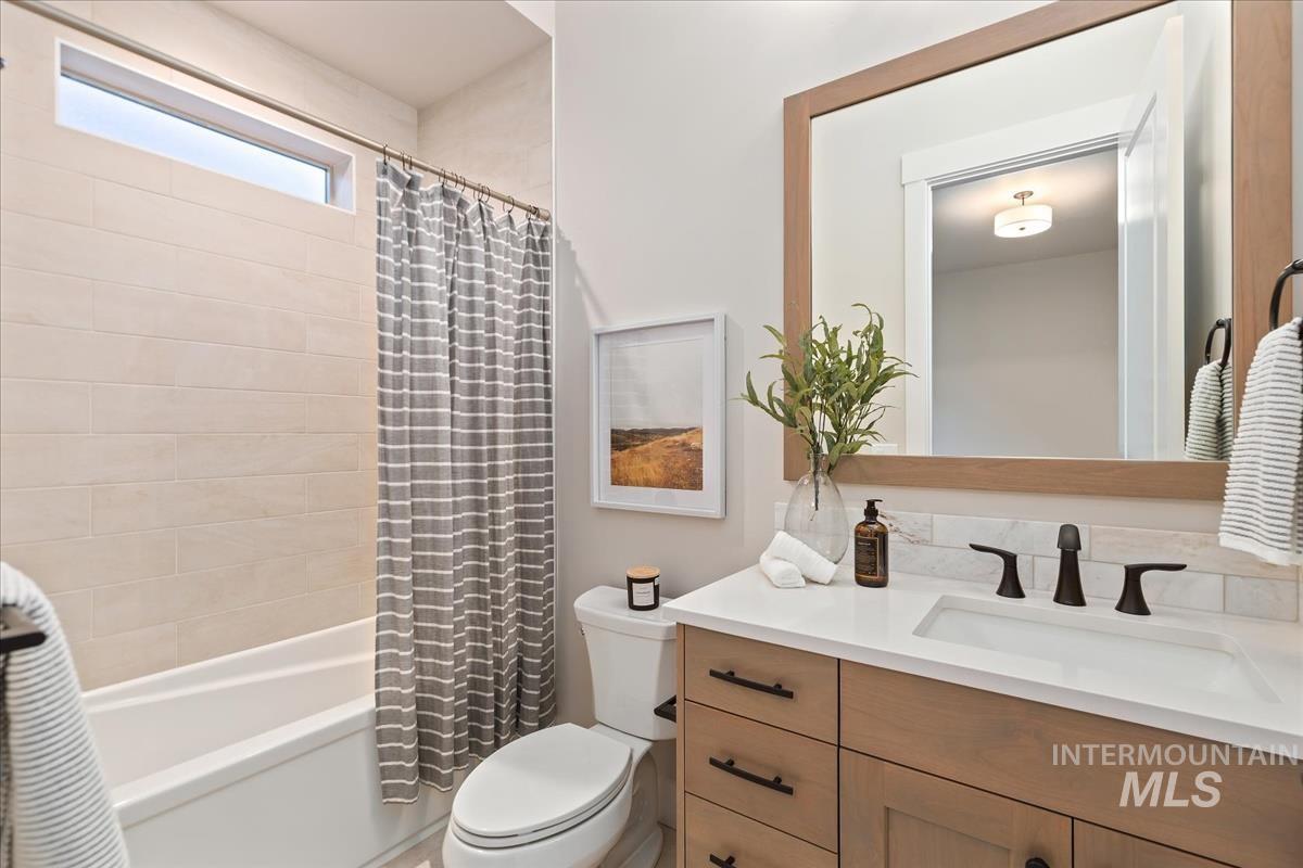 7355 Powell Place Eagle, ID 83714 - Photo 30 of 37 Modern bathroom featuring a wood-tone vanity, integrated sink, and dark bronze fixtures