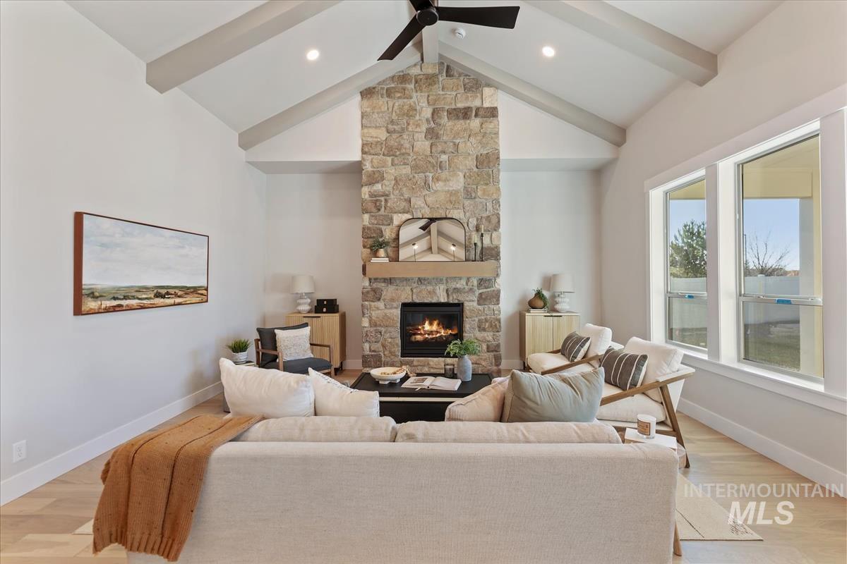 7355 Powell Place Eagle, ID 83714 - Photo 5 of 37 Vaulted ceilings with exposed beams complement the stone-clad fireplace, featuring a wood mantel