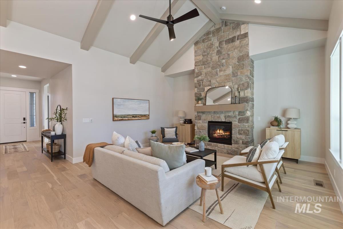 7355 Powell Place Eagle, ID 83714 - Photo 6 of 37 Light wood-finish flooring extends throughout this expansive living area, featuring a stone fireplace with a wood mantle