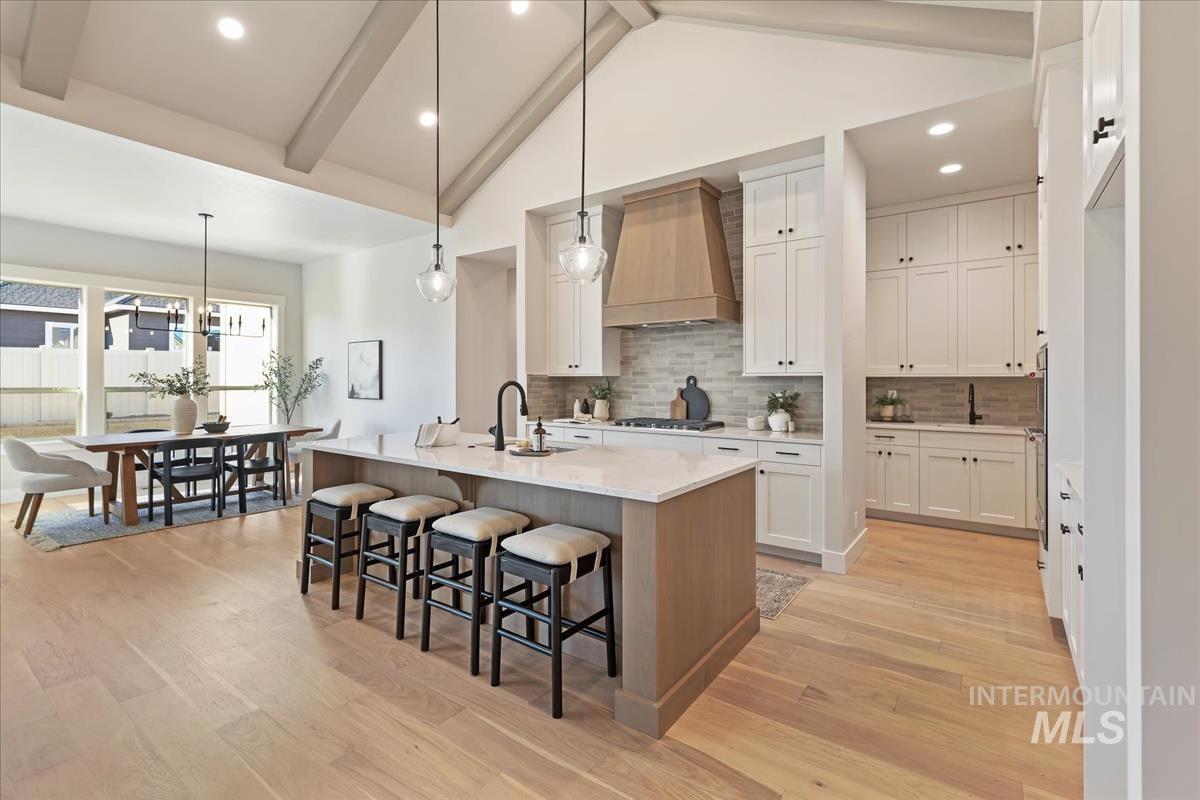 7355 Powell Place Eagle, ID 83714 - Photo 10 of 37 Vaulted ceilings with exposed beams complement the open kitchen and dining area
