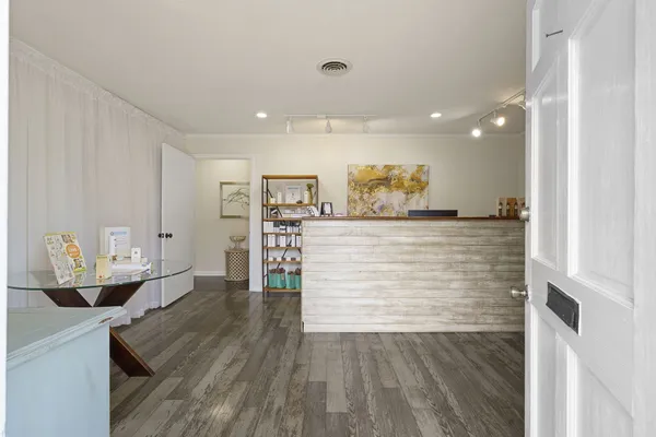 a view of a workspace with furniture and wooden floor