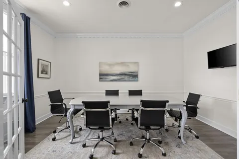 a work room with furniture and a flat screen tv