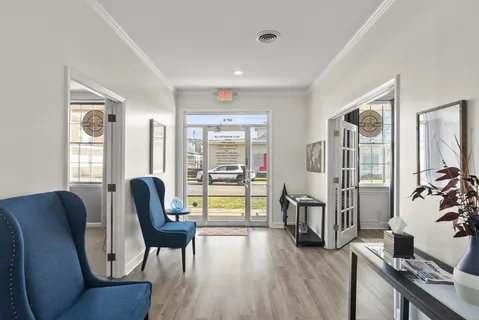 a view of a livingroom with furniture wooden floor and windows