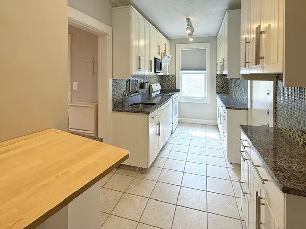 a kitchen with a sink a stove and cabinets