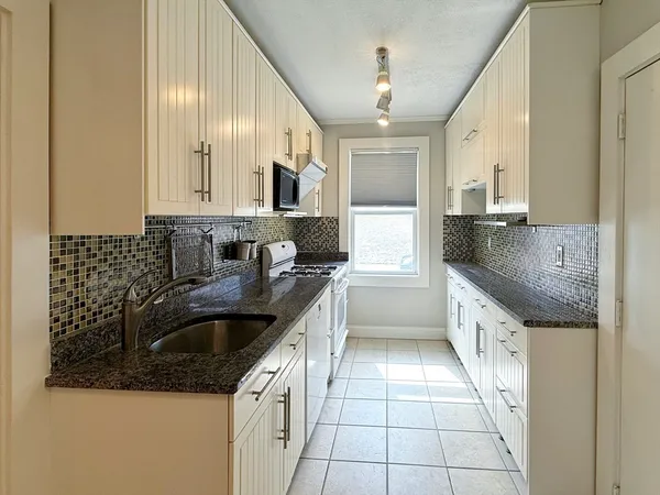 a kitchen with a sink stove top oven and cabinets