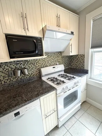 a kitchen with stainless steel appliances granite countertop a stove a microwave and a sink