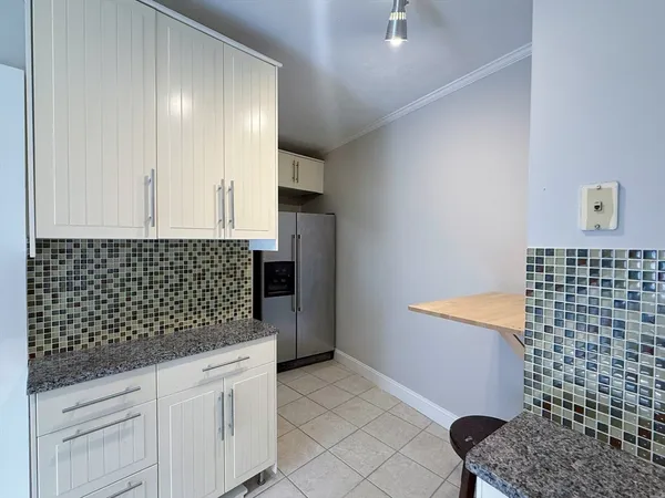 a kitchen with white cabinets and sink
