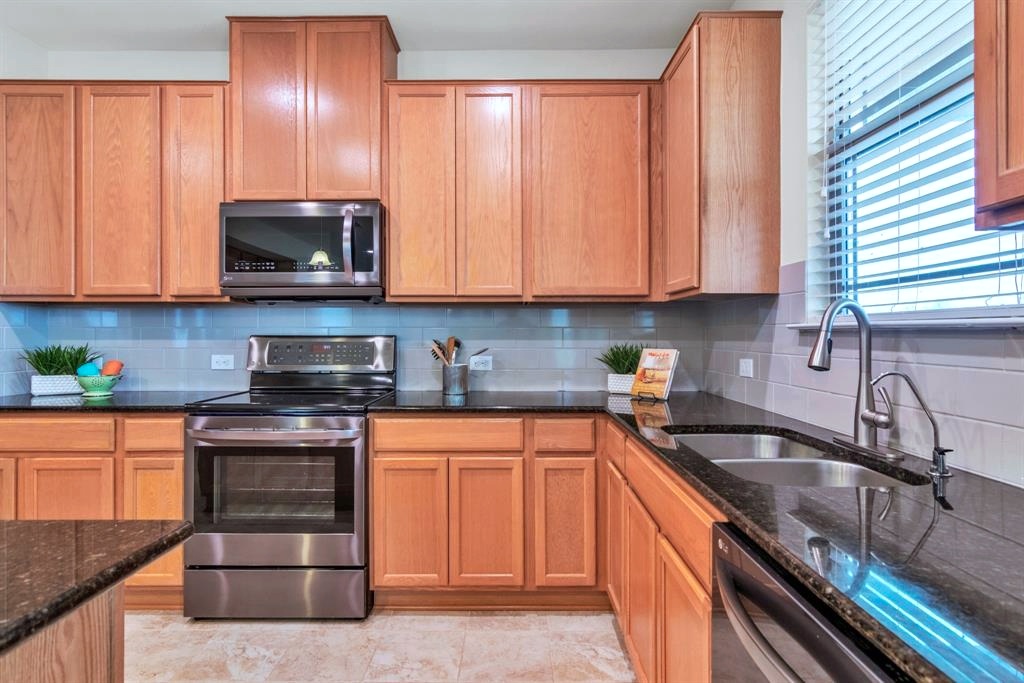 1075 Toltec Trail Georgetown, TX 78626 - Photo 4 of 32 a kitchen with granite countertop a sink stainless steel appliances and cabinets