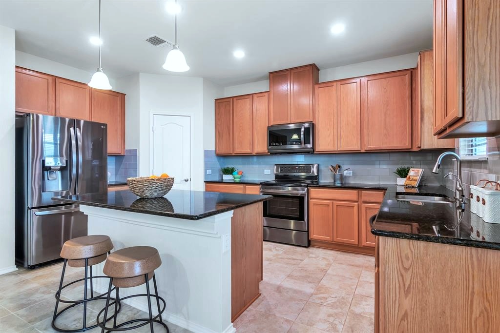 1075 Toltec Trail Georgetown, TX 78626 - Photo 7 of 32 a kitchen with stainless steel appliances granite countertop a refrigerator stove microwave and sink