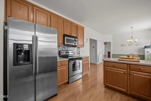 a kitchen with stainless steel appliances granite countertop a sink stove and cabinets