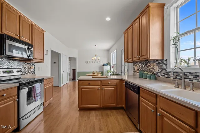 a kitchen with stainless steel appliances granite countertop a sink stove and cabinets