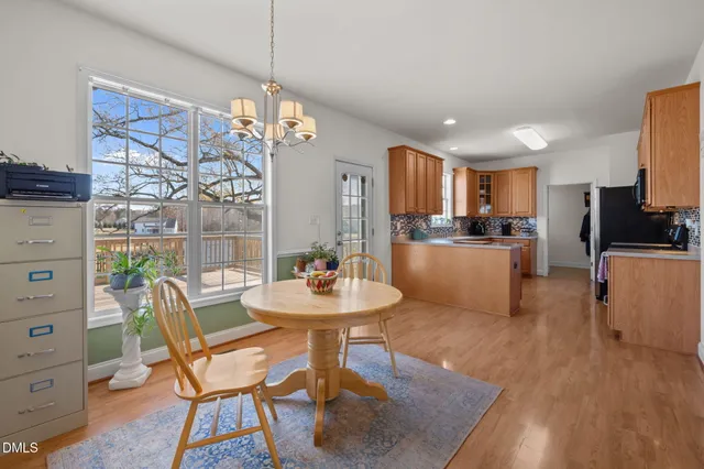 a dining room with furniture a chandelier and wooden floor