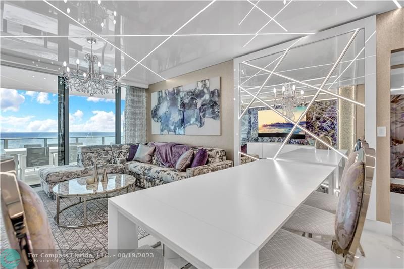 730 North Ocean Boulevard, Unit 503 Pompano Beach, FL 33062 - Photo 3 of 85 a view of a dining room with furniture a chandelier and large windows