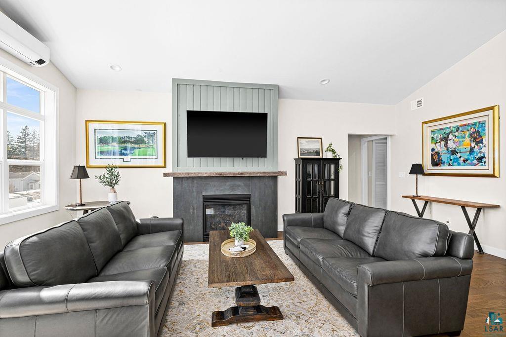 2236 Hoover Street Duluth, MN 55811 - Photo 6 of 52 Living area with a glass covered fireplace, wood finished floors, and lofted ceiling