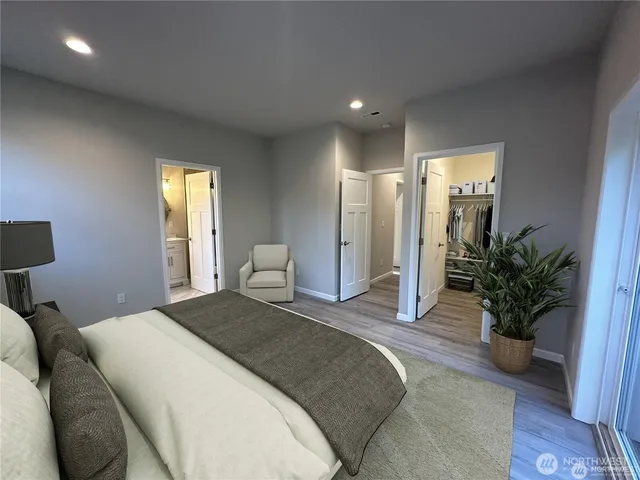 a spacious bedroom with a bed and a potted plant